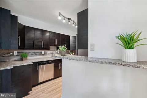 a kitchen with stainless steel appliances granite countertop a sink a stove and cabinets