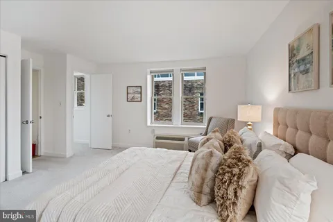 a bedroom with a bed and a large window