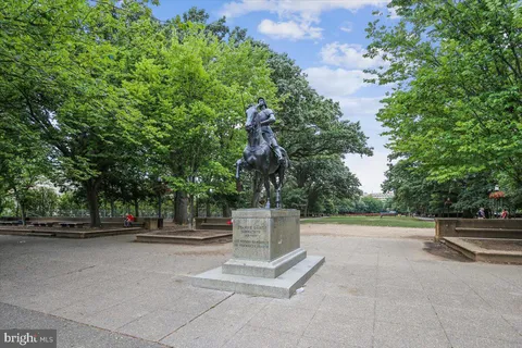 a view of street with bench and trees