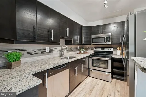 a kitchen with kitchen island granite countertop a sink stainless steel appliances and counter space