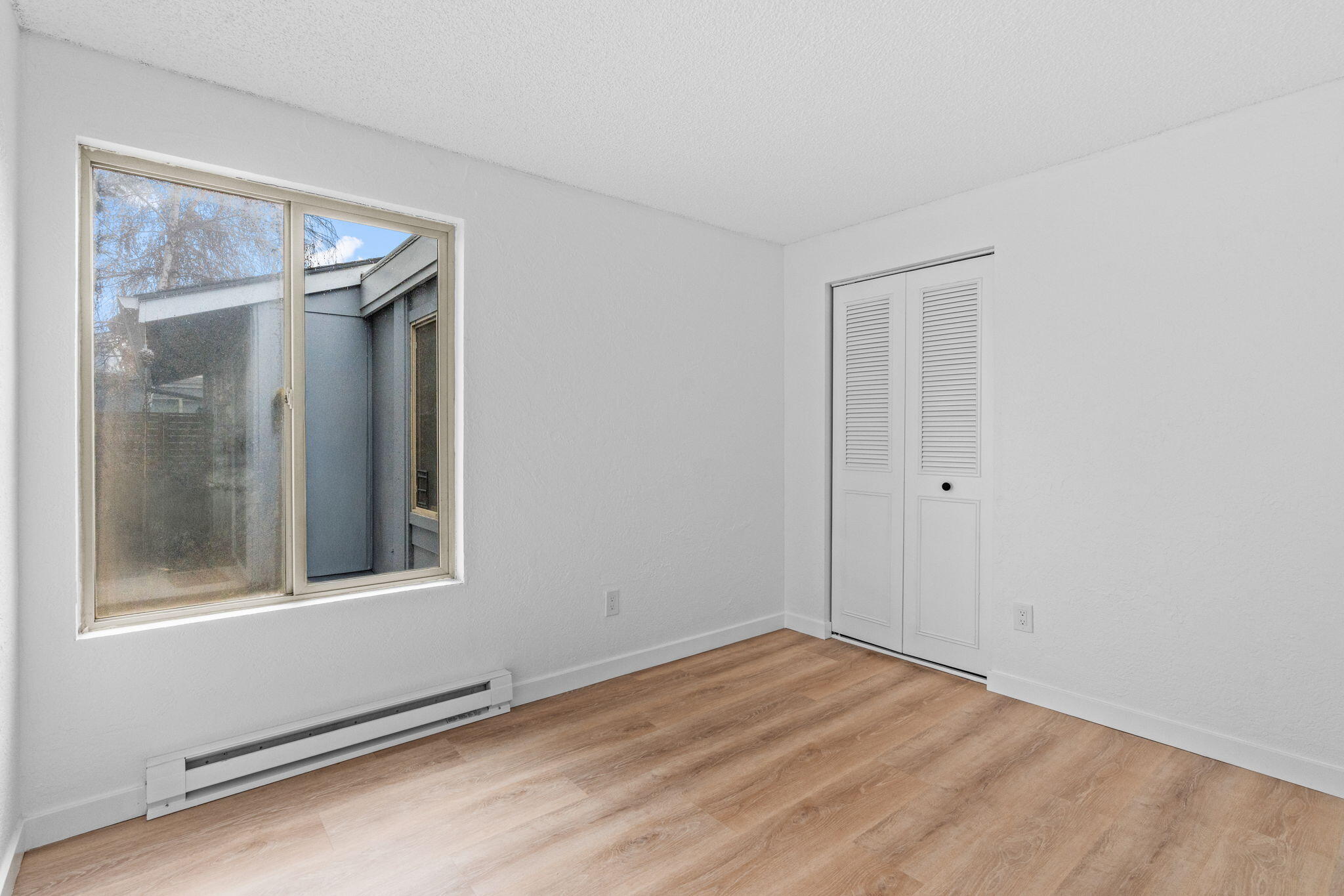 1700 Northeast Wells Acres Road, Unit 25 Bend, OR 97701 - Photo 22 of 25 a view of an empty room with wooden floor and a window
