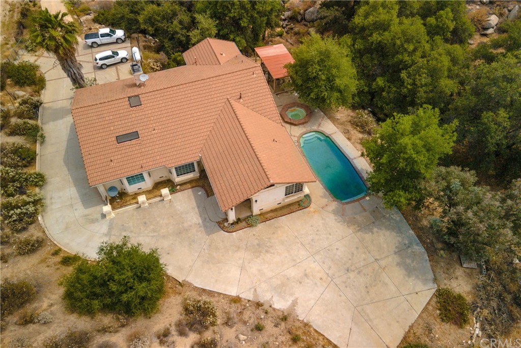 an aerial view of a house with a yard and pool