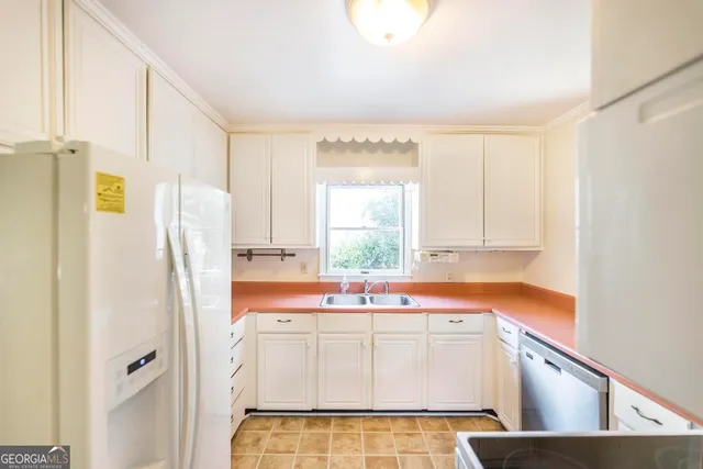 a kitchen with a refrigerator sink and cabinets