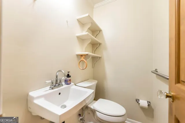 a bathroom with a sink a toilet and mirror