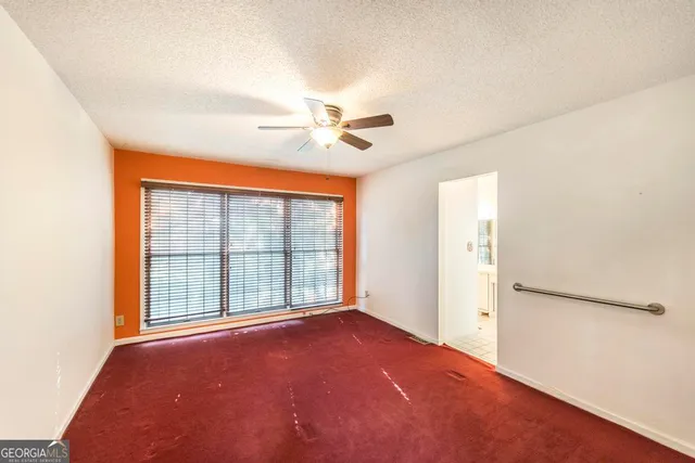 an empty room with a ceiling fan and a window
