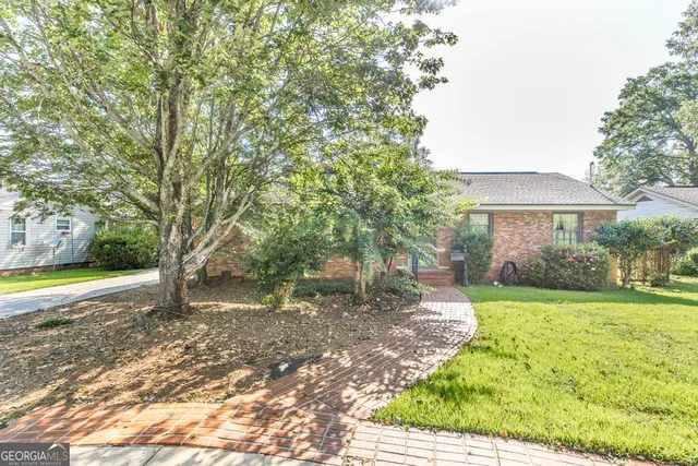 a view of a house with backyard and a tree