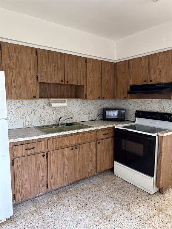 5925 Southwest 27th Street, Unit 1 West Park, FL 33023 - Photo 9 of 12 a kitchen with granite countertop a sink cabinets and stainless steel appliances