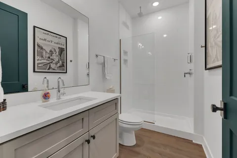 a bathroom with a granite countertop sink a toilet and shower