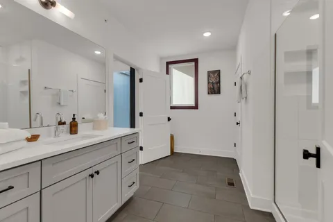 a spacious bathroom with a shower sink and mirror