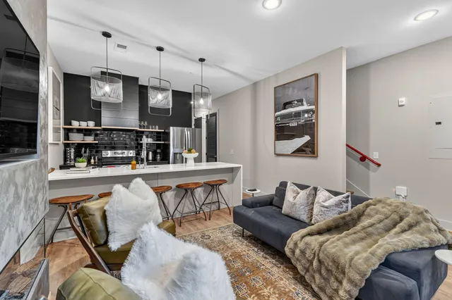 a living room with furniture and kitchen view