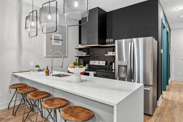 a kitchen with stainless steel appliances granite countertop a sink refrigerator and cabinets