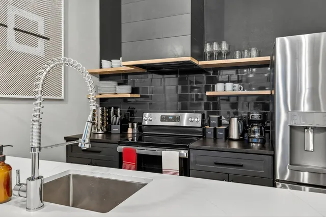 a kitchen with stainless steel appliances kitchen island granite countertop a refrigerator and a stove