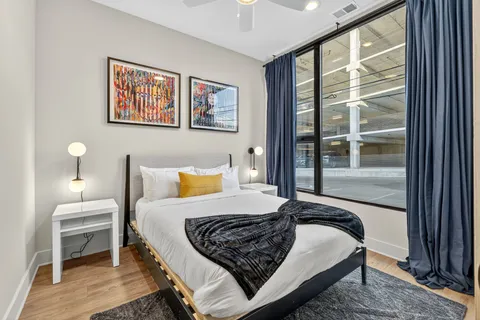 a bedroom with a bed wooden floor and window