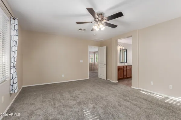 en empty room with windows and ceiling fan