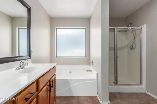 a bathroom with a tub sink and mirror