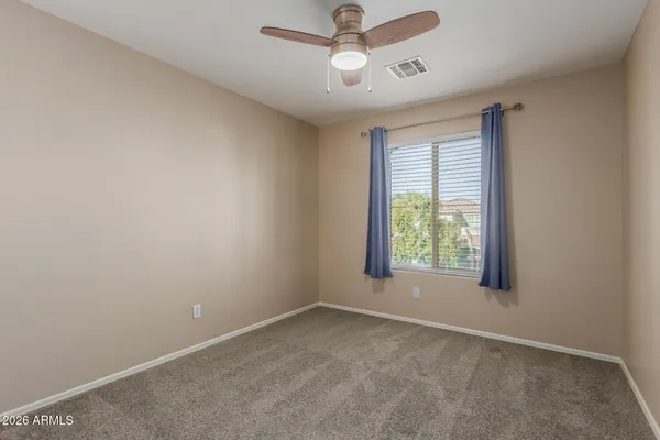 an empty room with a window and ceiling fan