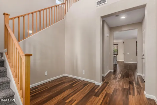 a view of a hallway with wooden floor and staircase