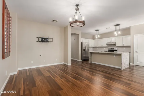a view of kitchen with granite countertop stainless steel appliances cabinets a sink and a wooden floor