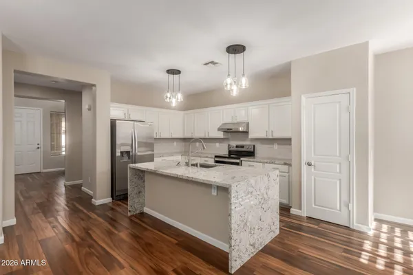 a kitchen with kitchen island a stove a refrigerator and a sink