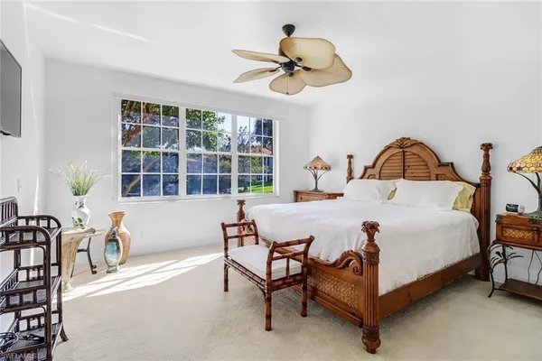 a bedroom with a bed chandelier and a window