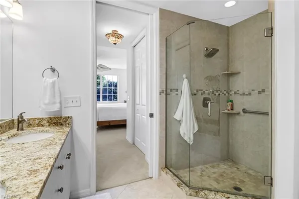 a en suite bathroom with a granite countertop shower and a sink