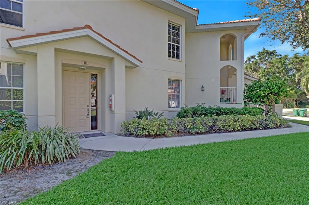 1301 Egrets Landing, Unit 101 Naples, FL 34108 - Photo 2 of 25 a front view of a house with a garden