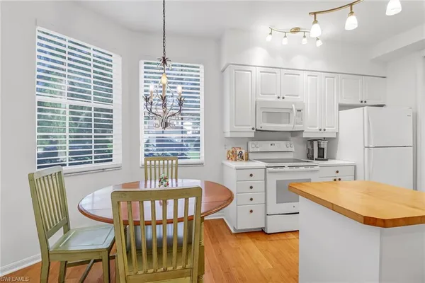 a kitchen with a table chairs and refrigerator