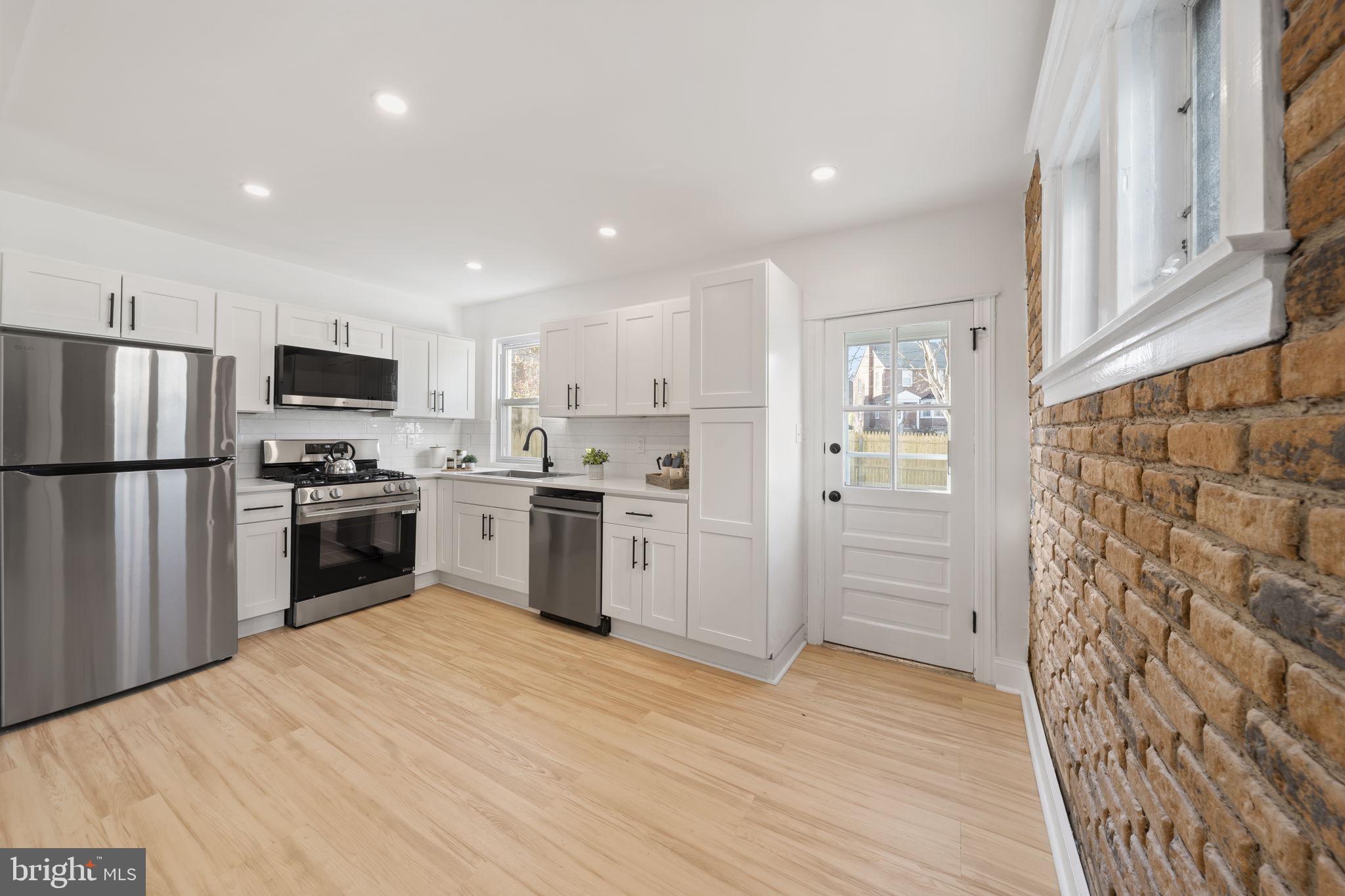 2517 Marshall Road Drexel Hill, PA 19026 - Photo 13 of 29 a kitchen with granite countertop a refrigerator stove and wooden floor