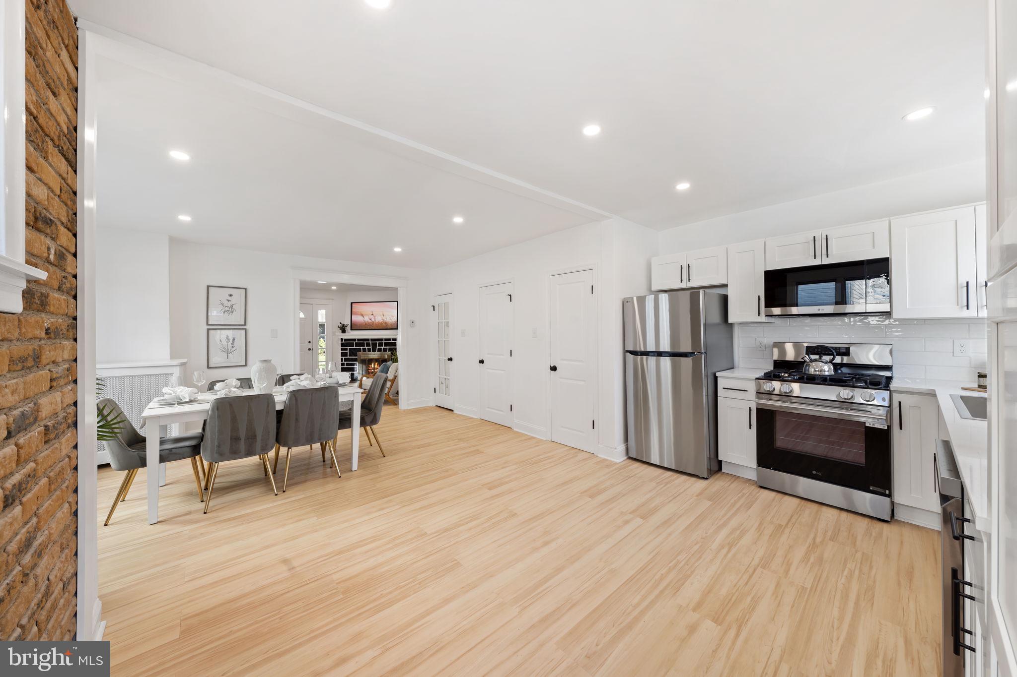 2517 Marshall Road Drexel Hill, PA 19026 - Photo 17 of 29 a kitchen with stainless steel appliances kitchen island granite countertop a refrigerator a stove a sink a dining table and chairs with wooden floor