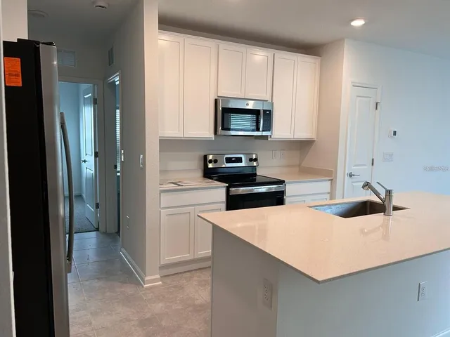 a kitchen with white cabinets and stainless steel appliances