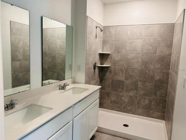 a bathroom with a shower sink and mirror