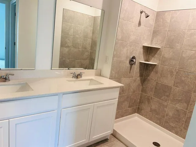 a bathroom with a sink a toilet a mirror and shower