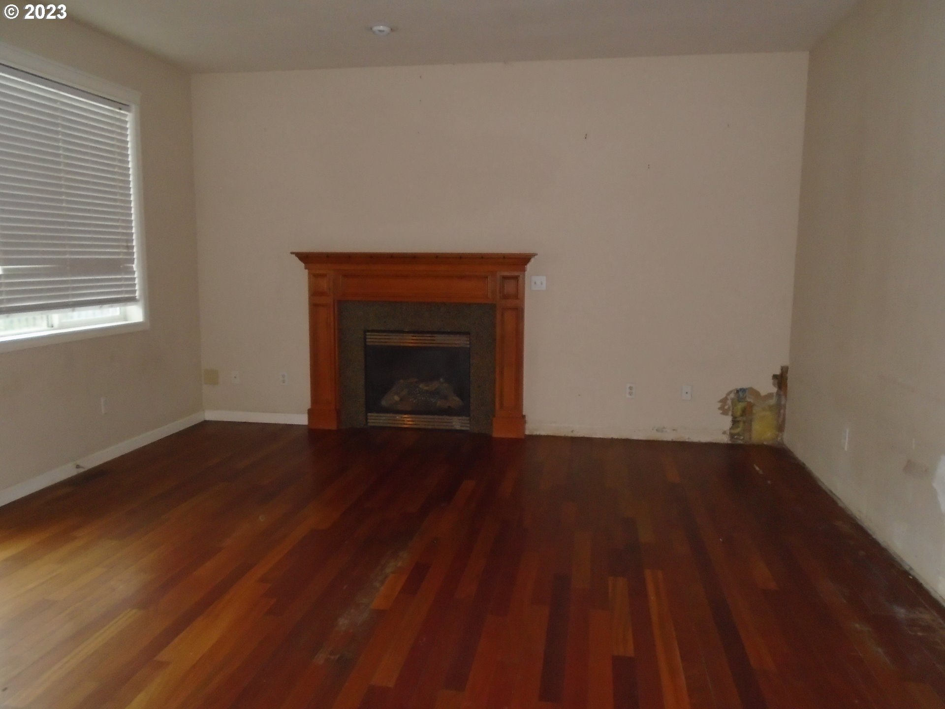 1710 South Dusky Drive Ridgefield, WA 98642 - Photo 6 of 16 a view of an empty room with wooden floor and a fireplace