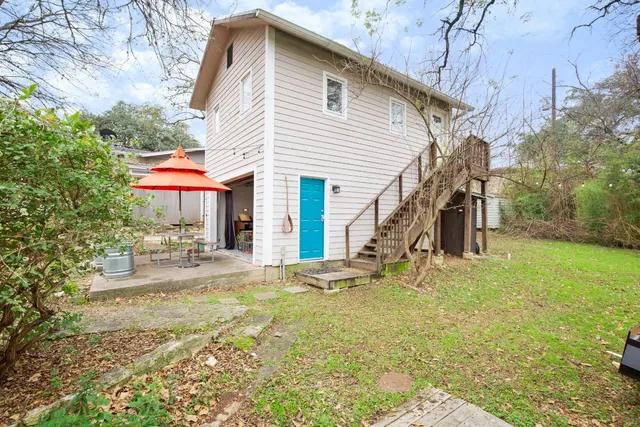 a view of a house with backyard and sitting area