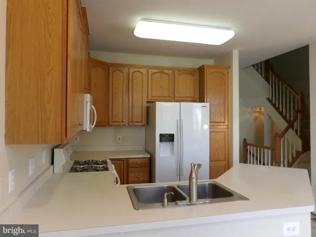 a kitchen with a sink a refrigerator and a stove