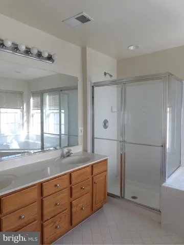 a spacious bathroom with double vanity and a mirror