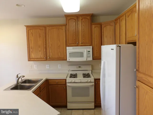 a kitchen with a refrigerator sink and cabinets