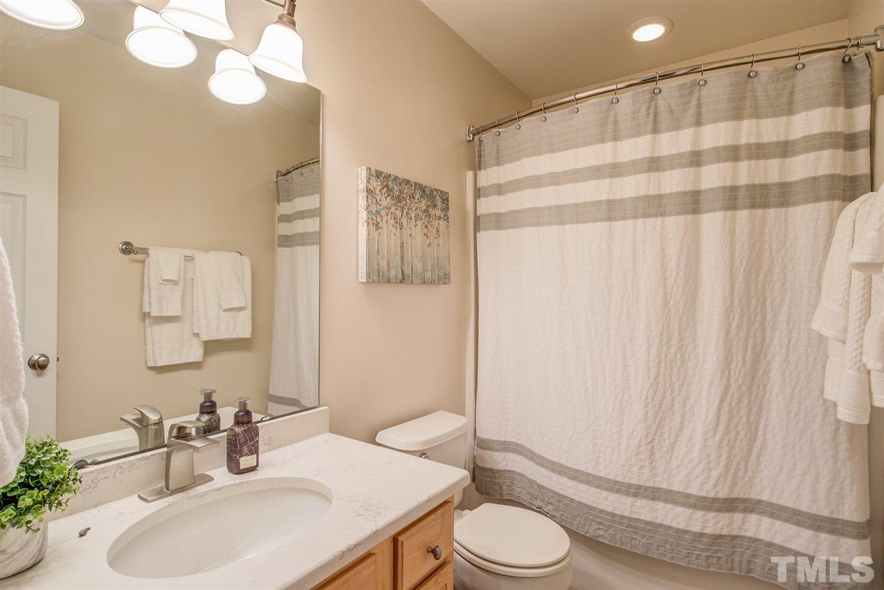 9535 Hanging Rock Road Raleigh, NC 27613 - Photo 17 of 27 a bathroom with a sink a toilet and shower curtain