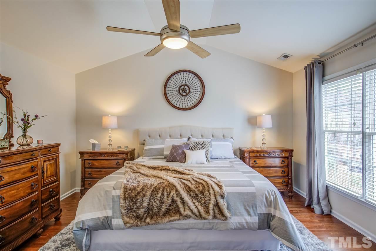 9535 Hanging Rock Road Raleigh, NC 27613 - Photo 21 of 27 a bedroom with a bed and a chandelier
