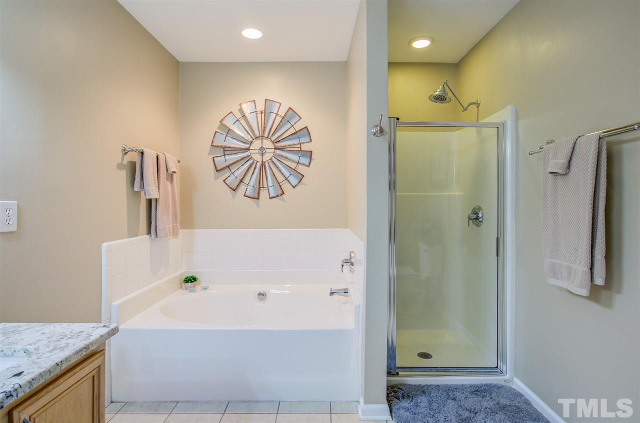 9535 Hanging Rock Road Raleigh, NC 27613 - Photo 23 of 27 a bathroom with a bathtub and a shower