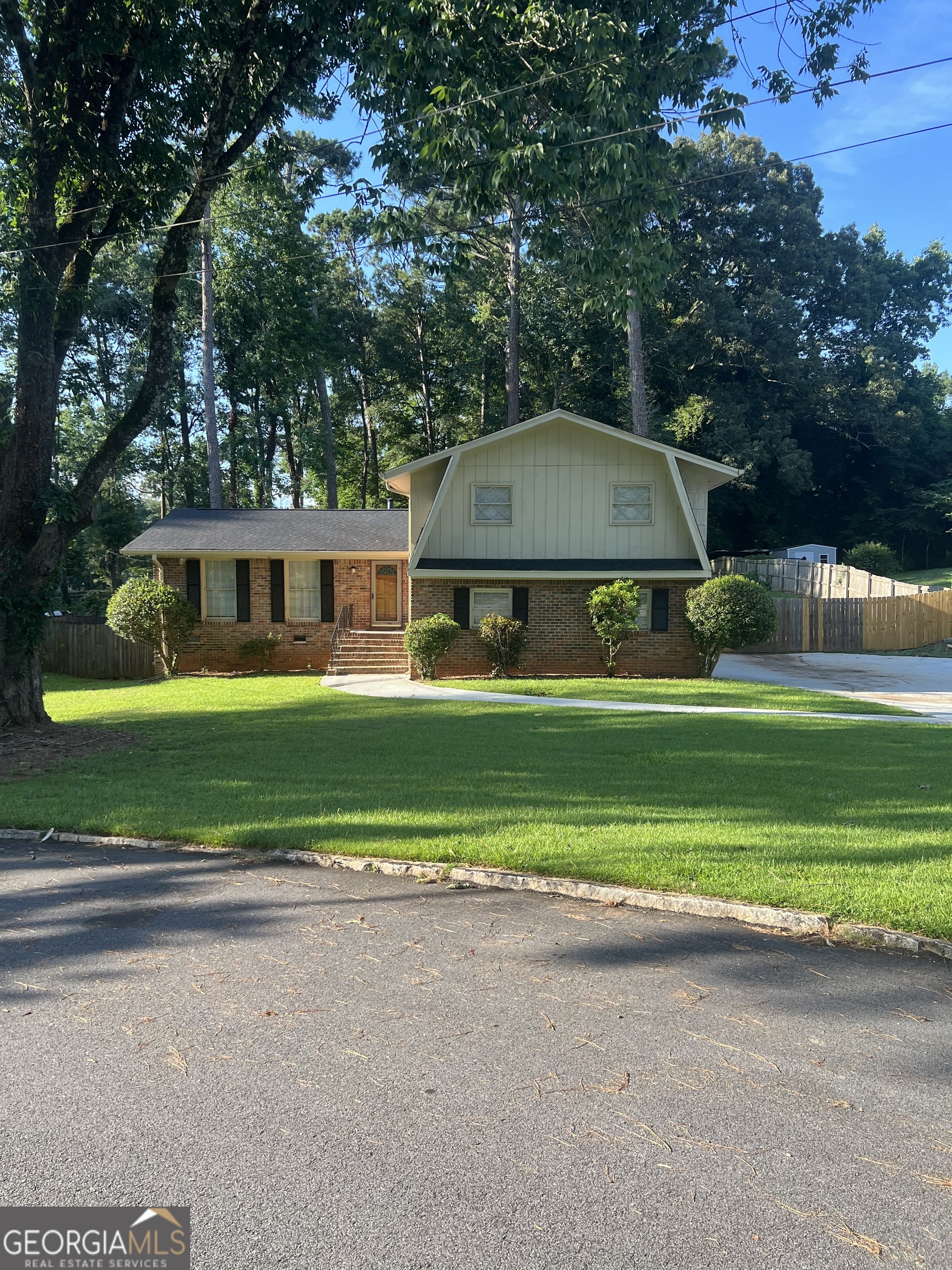 a front view of a house with a yard and trees