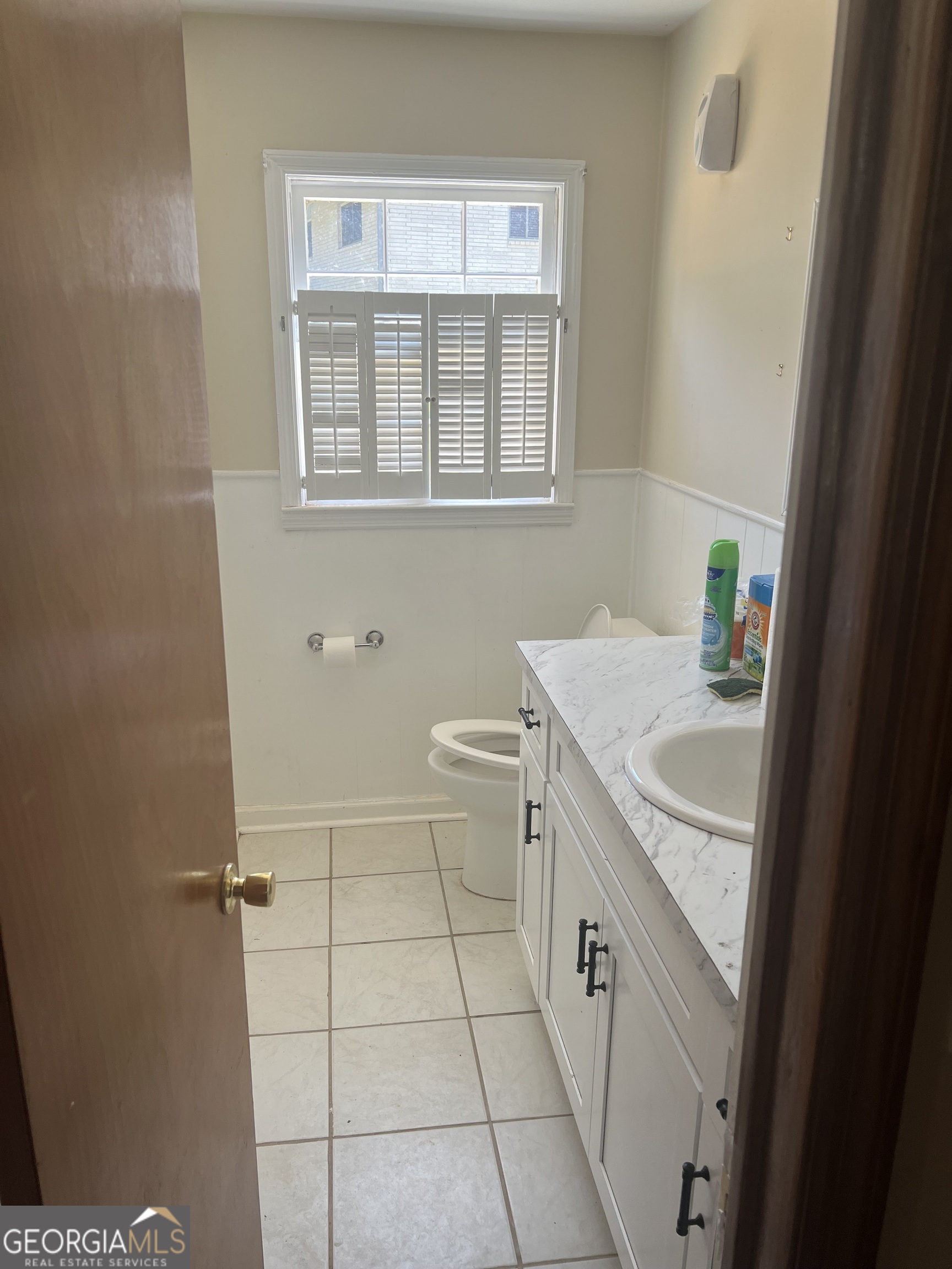 4910 Thompson Mill Road Lithonia, GA 30038 - Photo 11 of 28 a bathroom with a sink a toilet and a window