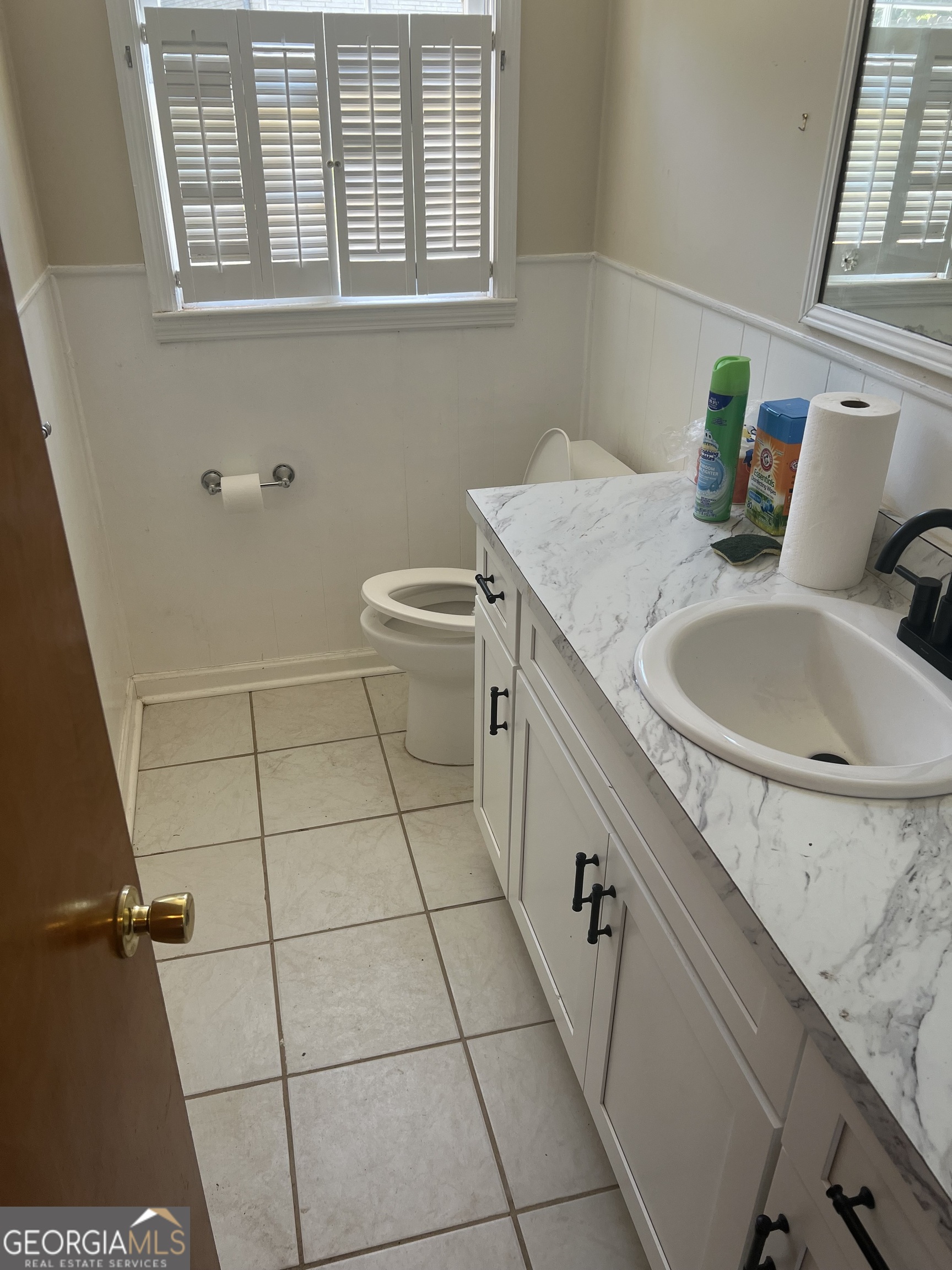 4910 Thompson Mill Road Lithonia, GA 30038 - Photo 12 of 28 a bathroom with a granite countertop sink a toilet and mirror