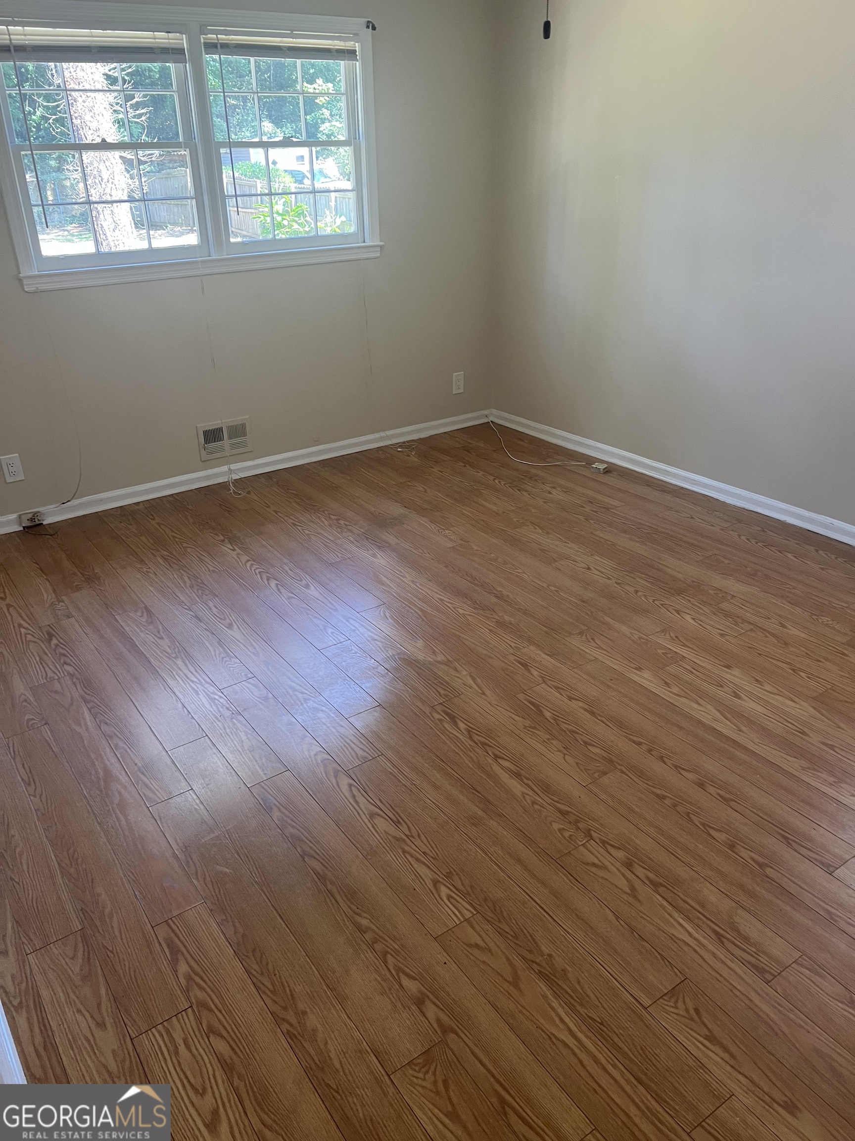 4910 Thompson Mill Road Lithonia, GA 30038 - Photo 18 of 28 an empty room with wooden floor and windows