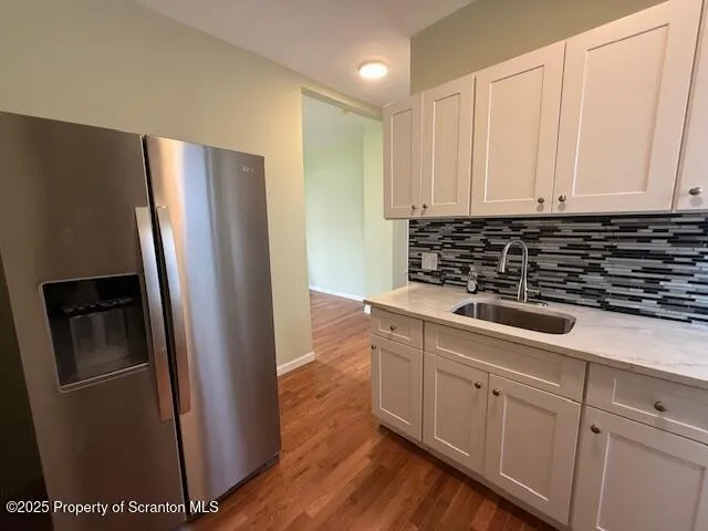 a kitchen with a refrigerator sink and cabinets