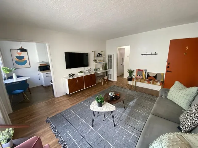 a living room with furniture a rug and a flat screen tv