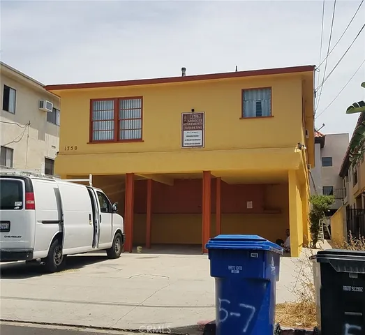 a view of a house with a barbeque and wooden stairs
