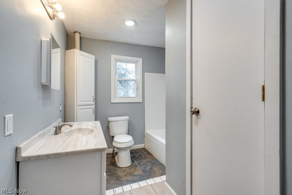 1607 9th Street Southwest Canton, OH 44706 - Photo 28 of 41 Bathroom featuring a single vanity with a light-toned countertop, built-in medicine cabinet, and overhead light fixture
