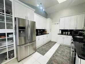 a kitchen with stainless steel appliances kitchen island granite countertop a refrigerator and a stove top oven