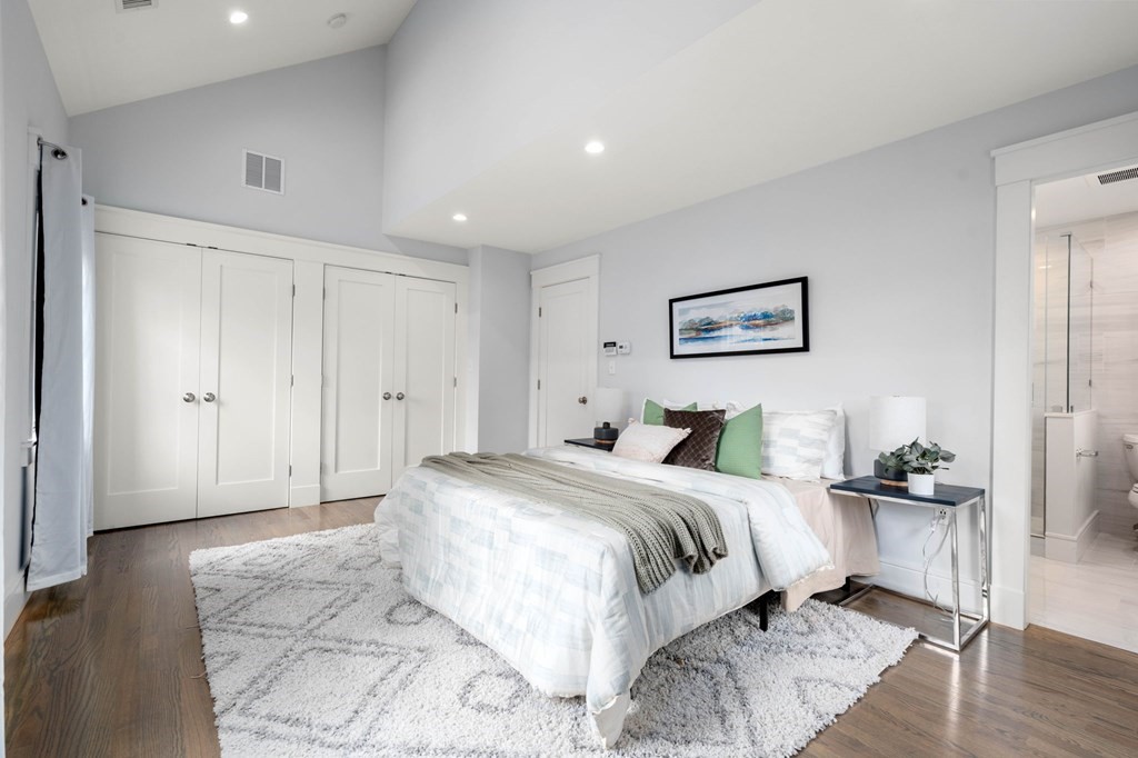 154 Spring Street, Unit 154 Watertown, MA 02472 - Photo 16 of 27 a spacious bedroom with a bed and a painting